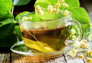 Traditional Russian linden tea, flowers and linden branches, a vintage wooden background, selective focus